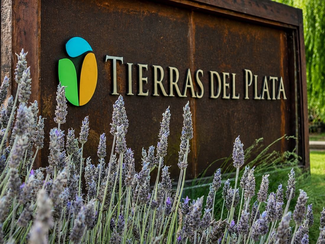 El cartel de entrada de Tierras del Plata, en acero, entre lavandas