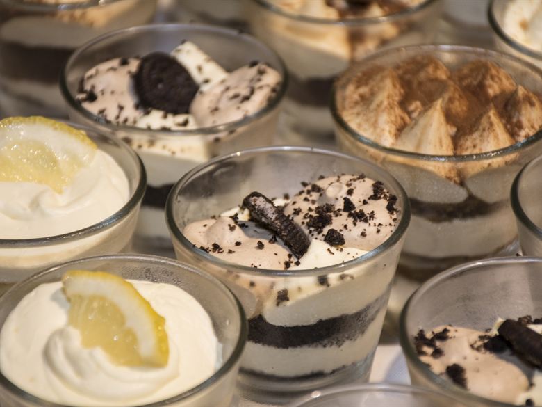 Copitas de lemon pie, chocotorta y mousse de chocolate, servidas en vaso de vidrio