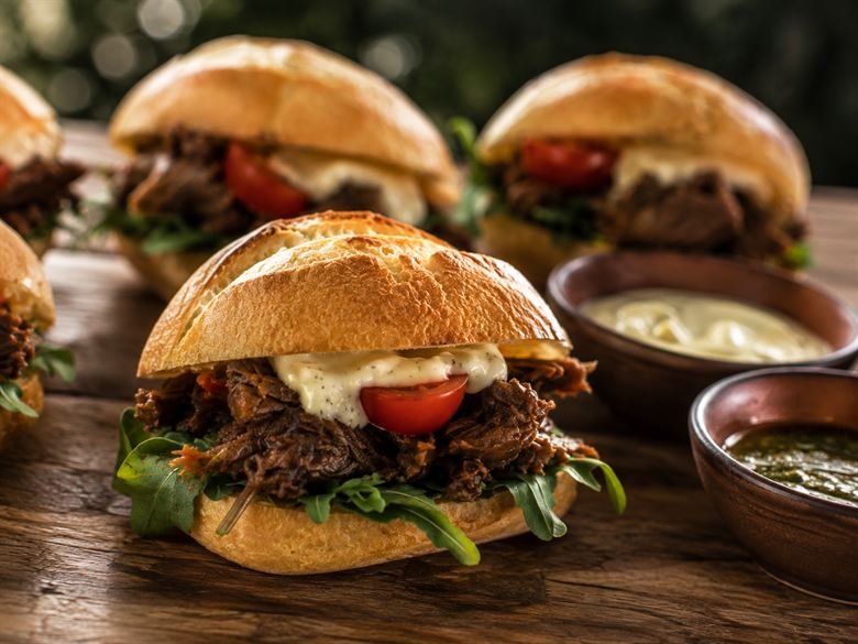 El sándwich de ternera en pan casero, con las salsas de la casa en cuencos al lado